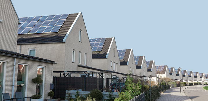 Aurinkopaneeleita suuren asuinalueen talojen katoilla. 