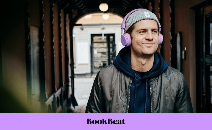 BookBeat-etu: mies kuuntelemassa äänikirjaa kuulokkeet päässä